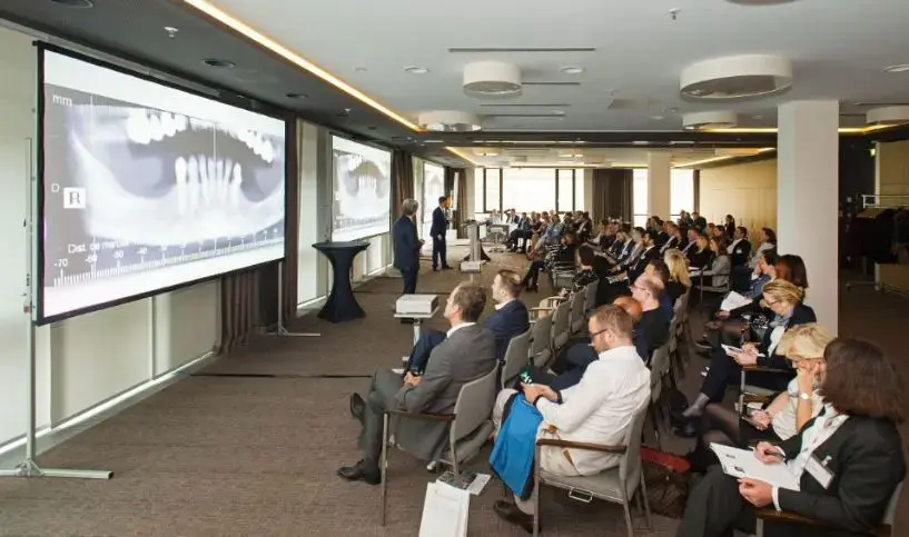 José Luis Domínguez-Mompell lecturing to an audience of dentists